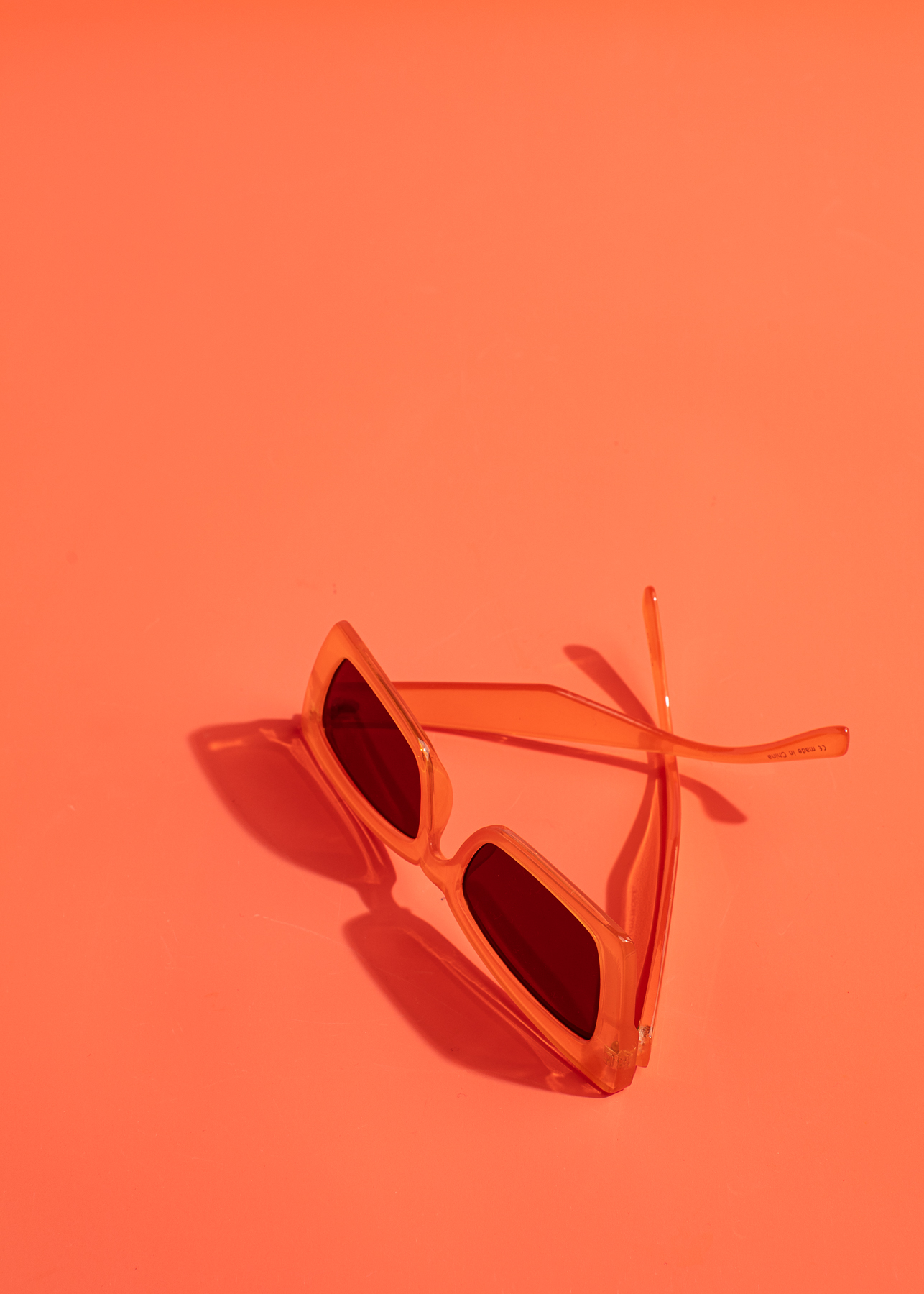 Orange sunglasses on an orange backdrop