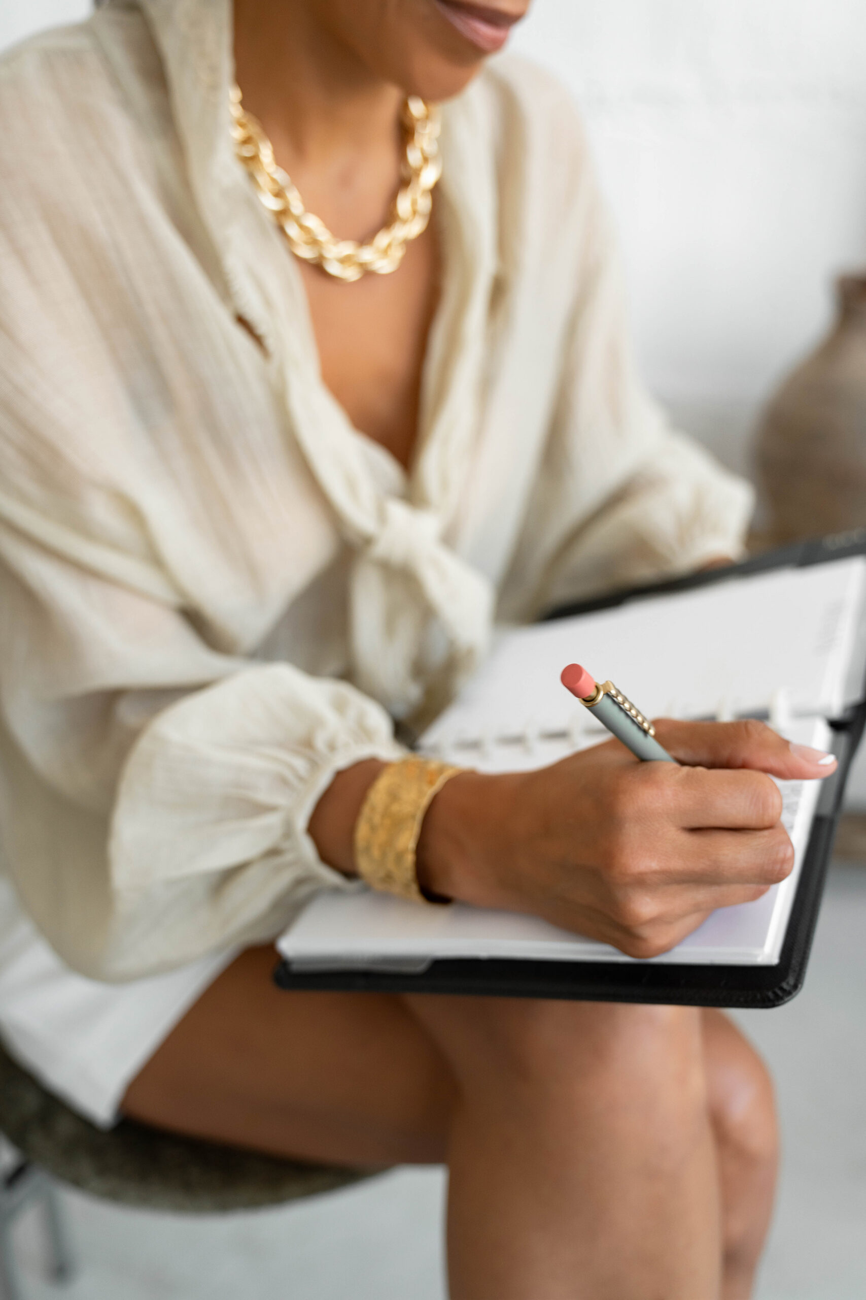 Close-up of a woman writing in a planner, representing strategy and avoiding common REALTOR® branding mistakes.